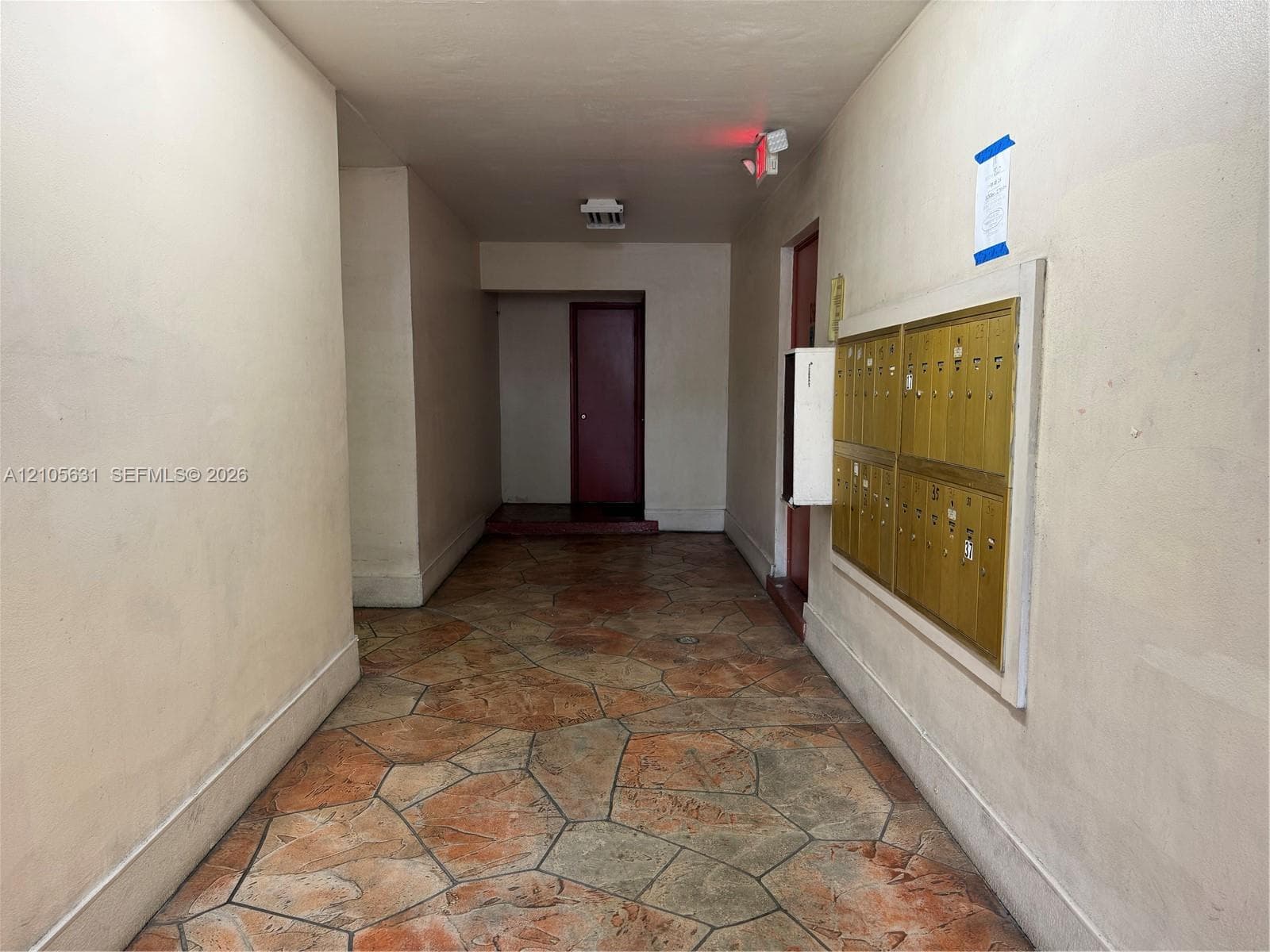 Interior hallway featuring flagstone-style flooring and a wall-mounted brass mail station
