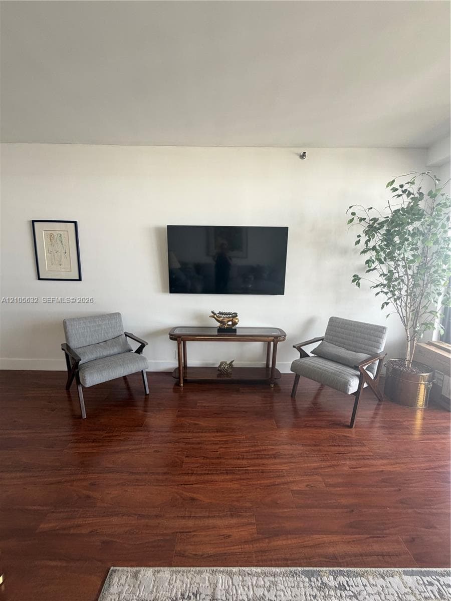 Living area featuring wood-finish flooring and a wall-mounted display fixture