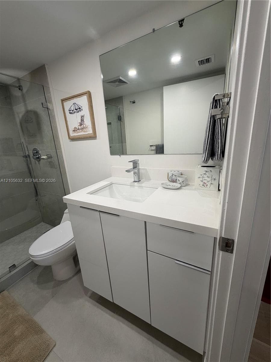 Modern white vanity featuring a clean-lined integrated sink, polished chrome faucet, and quartz countertop, paired with a glass-enclosed shower and large wall-mounted mirror