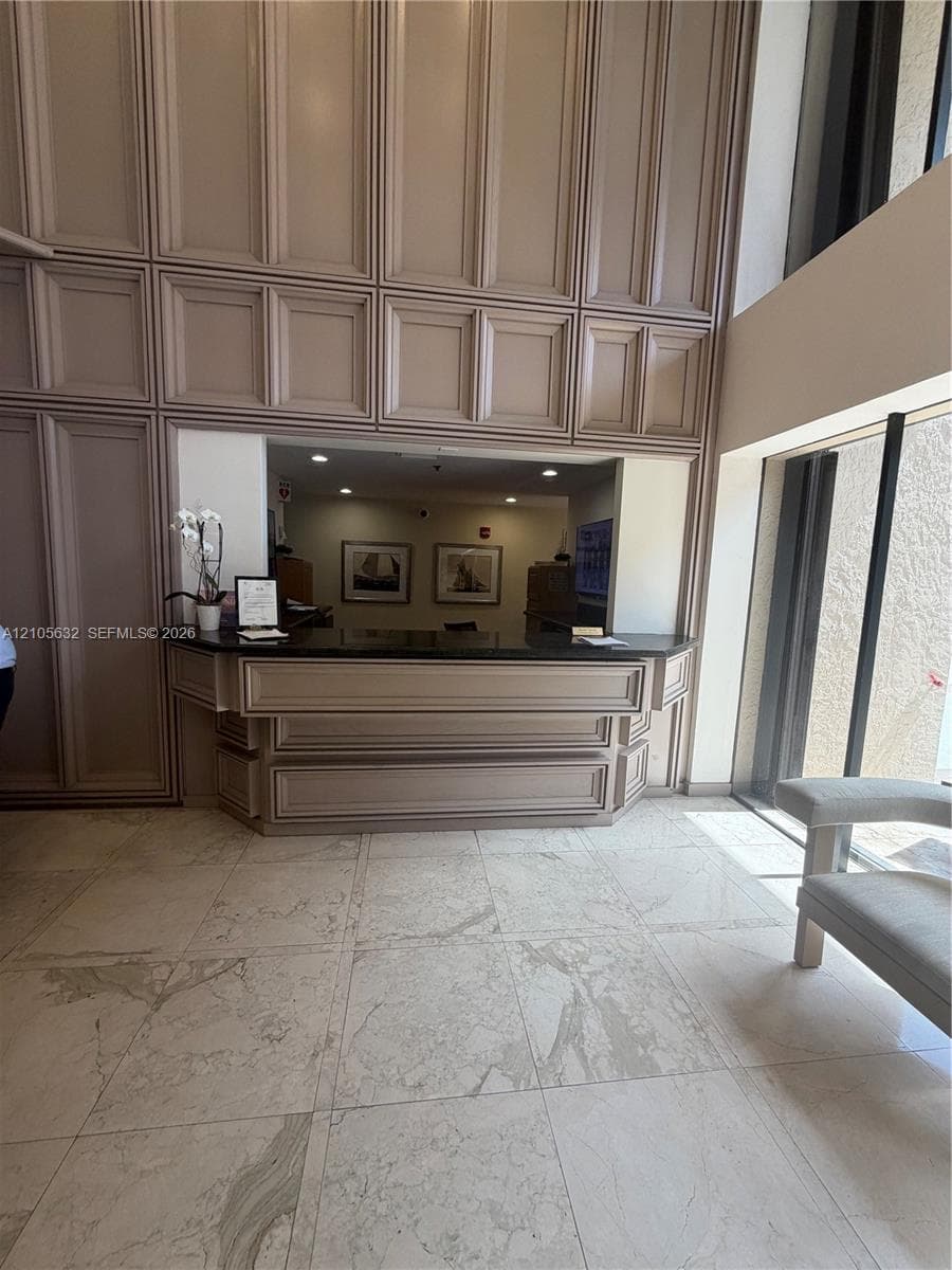 Full-height wall paneling, built-in service desk with stone-finish countertop, and large-format tile flooring