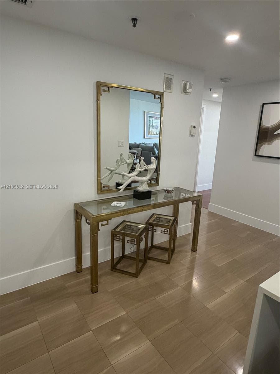Wood-finish flooring throughout, featuring neutral wall tones and recessed lighting