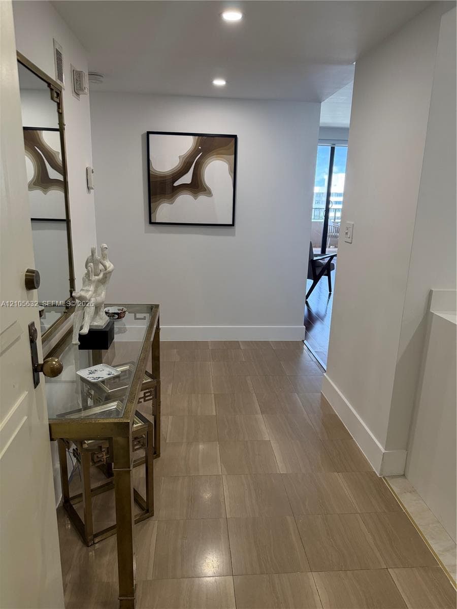 Neutral wall tones, recessed lighting, and tile flooring