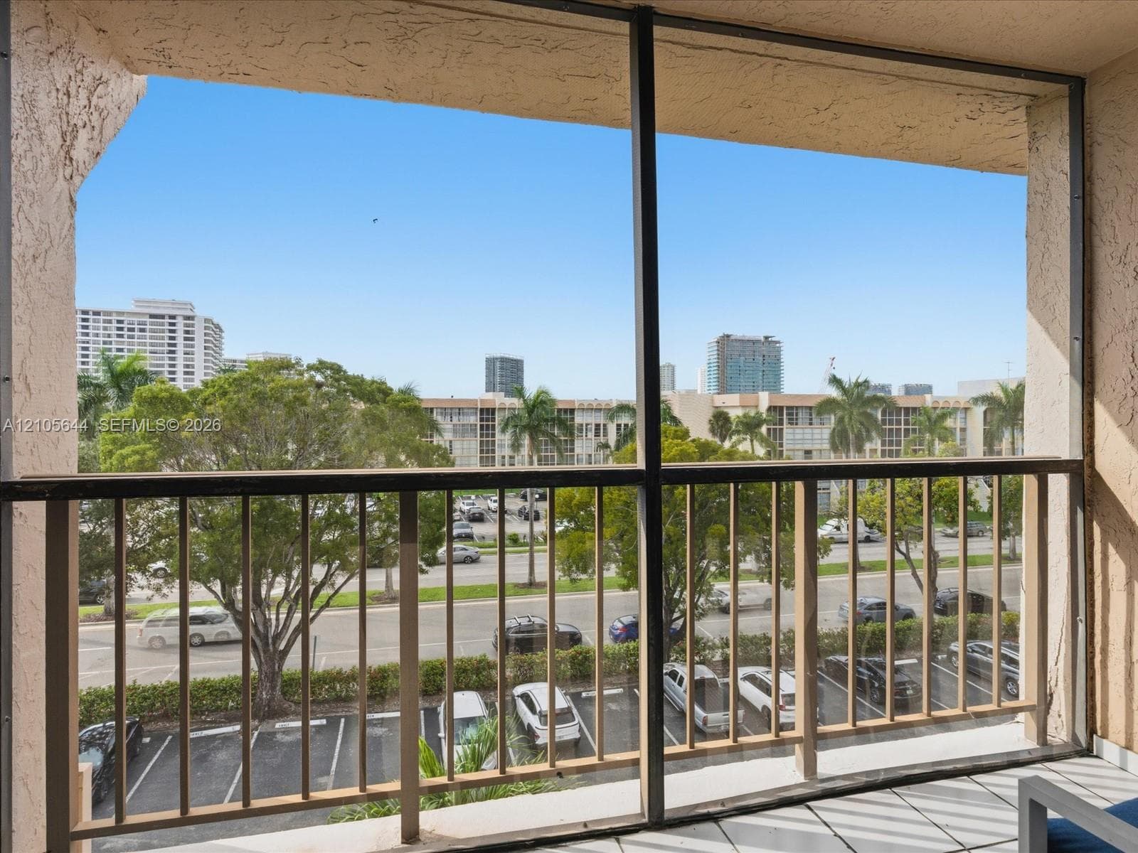 Screened-in balcony featuring tile flooring and metal railings