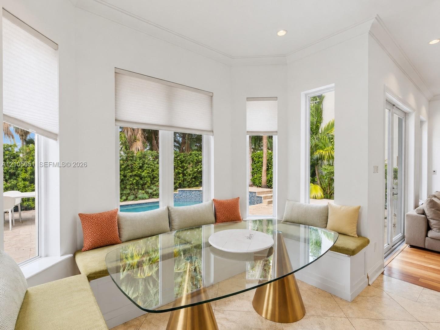 Bay window featuring built-in bench seating, recessed lighting, crown molding, and large-format tile flooring