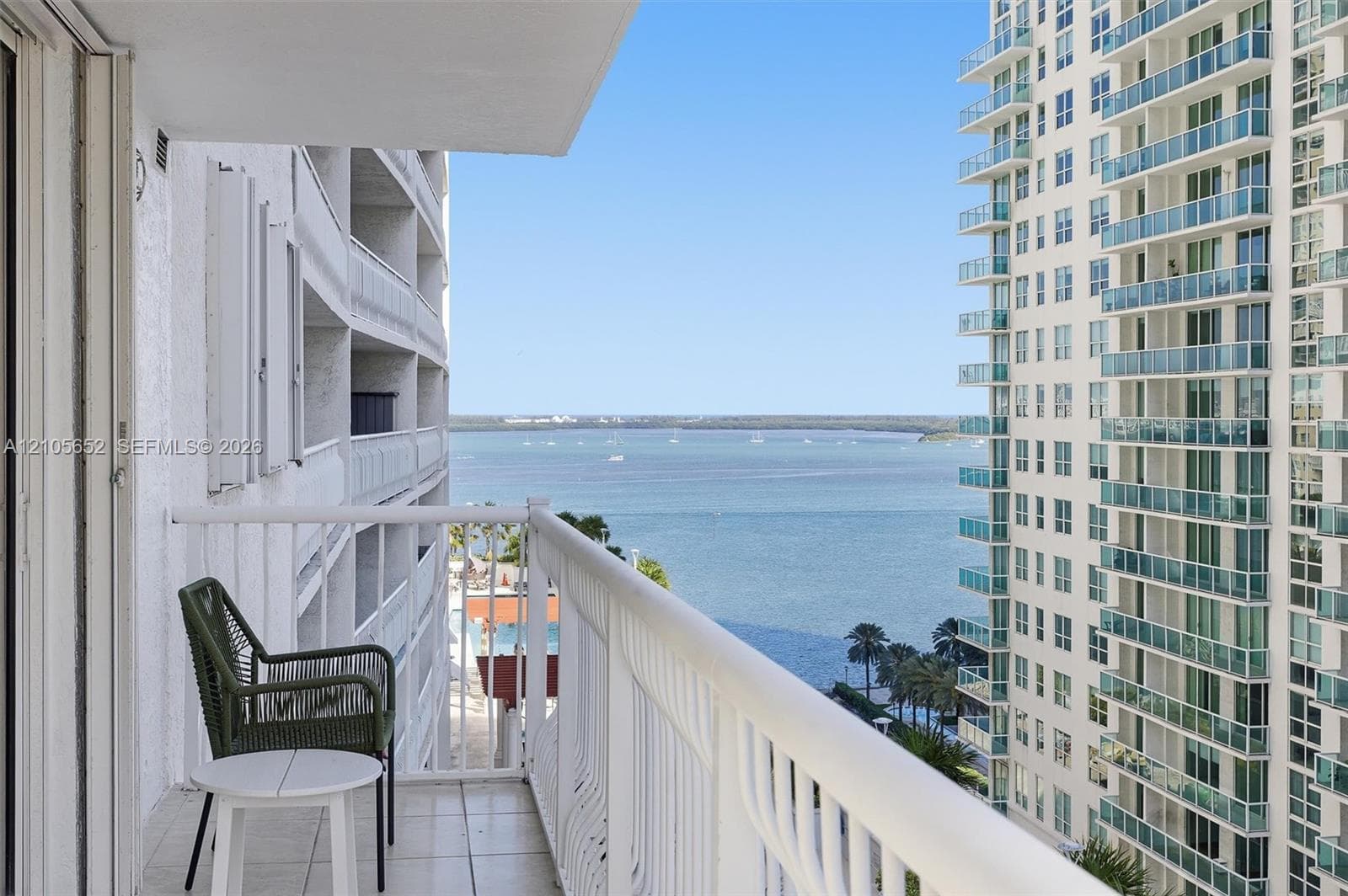 Private balcony featuring white metal railings, tile flooring, and direct water frontage