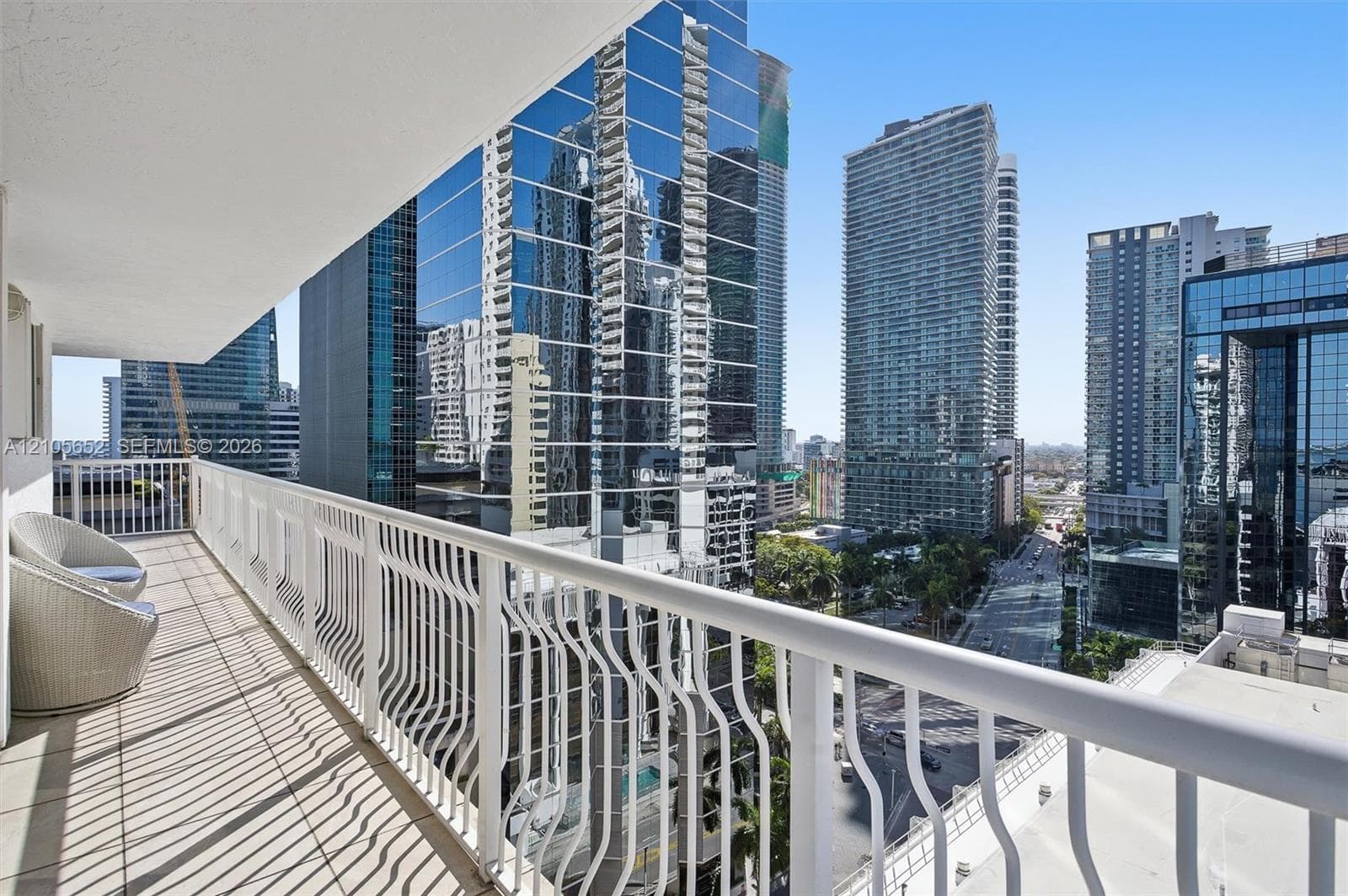Private covered balcony featuring white metal railings and tile flooring