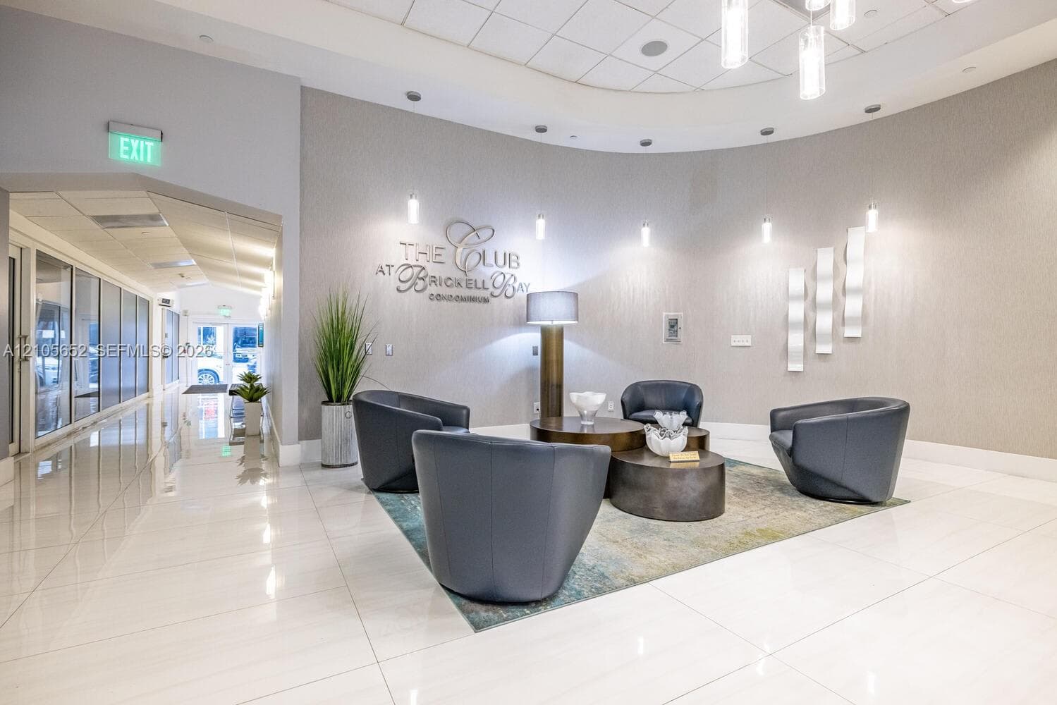 Circular lobby featuring polished tile flooring, recessed cove lighting, accent wall sconces, and a curved architectural design