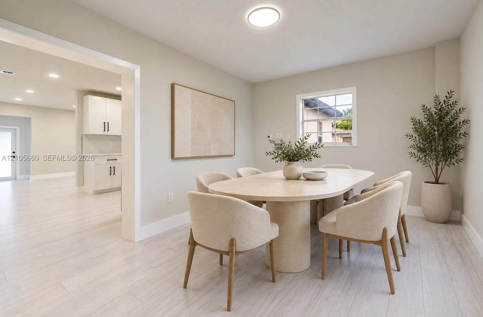 Neutral color palette featuring light wood-finish flooring, recessed lighting, and a single-pane window with muntins