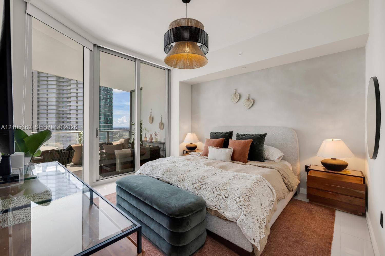 Floor-to-ceiling sliding glass doors, private balcony, contemporary multi-tiered pendant lighting, and polished tile flooring