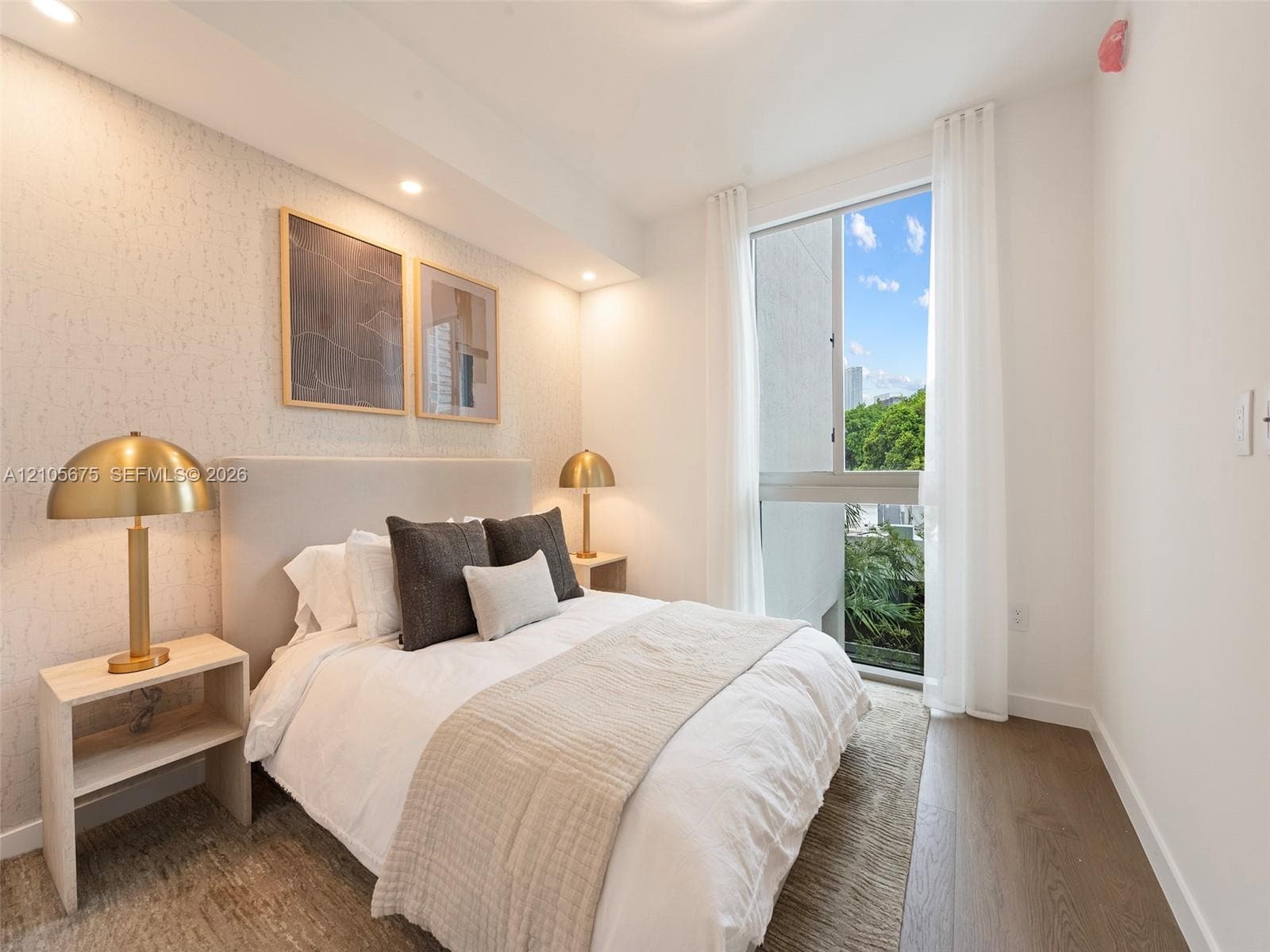 Bedroom featuring wood-finish flooring, textured wall covering, recessed lighting, and a large window with exterior greenery. Images are for finish purposes only. Please refer to the floor plan for the layout.