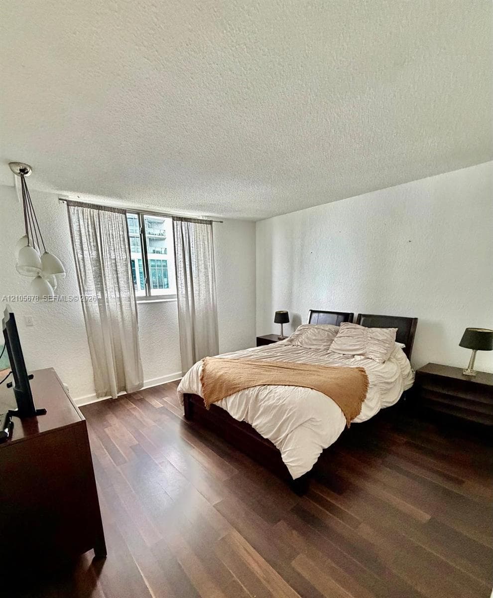 Wood-finish flooring, multi-globe pendant lighting, and a large window with natural light