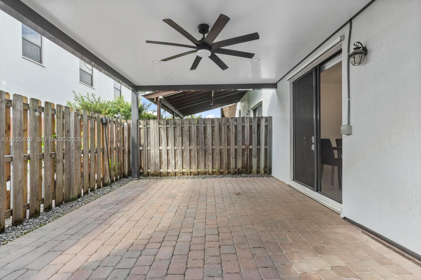 Covered patio featuring paver flooring, a multi-blade ceiling fan, recessed lighting, and a wood privacy fence