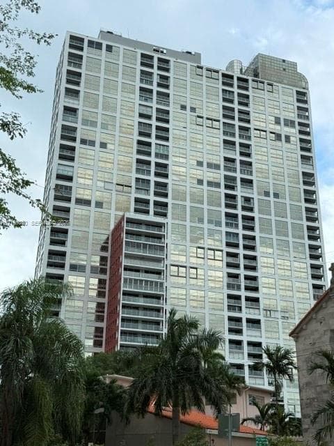 High-rise architectural exterior featuring glass-paneled facades, integrated private balconies, and a multi-textured finish
