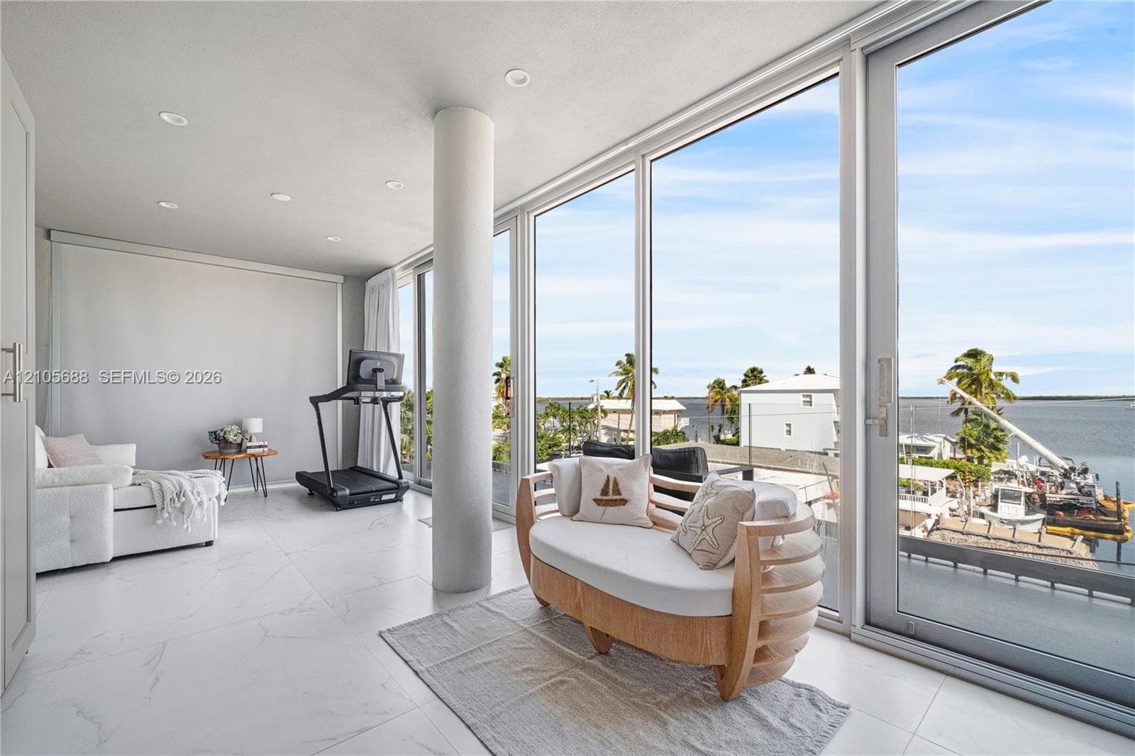 Floor-to-ceiling glass walls, polished stone-finish flooring, recessed lighting, and structural cylindrical column