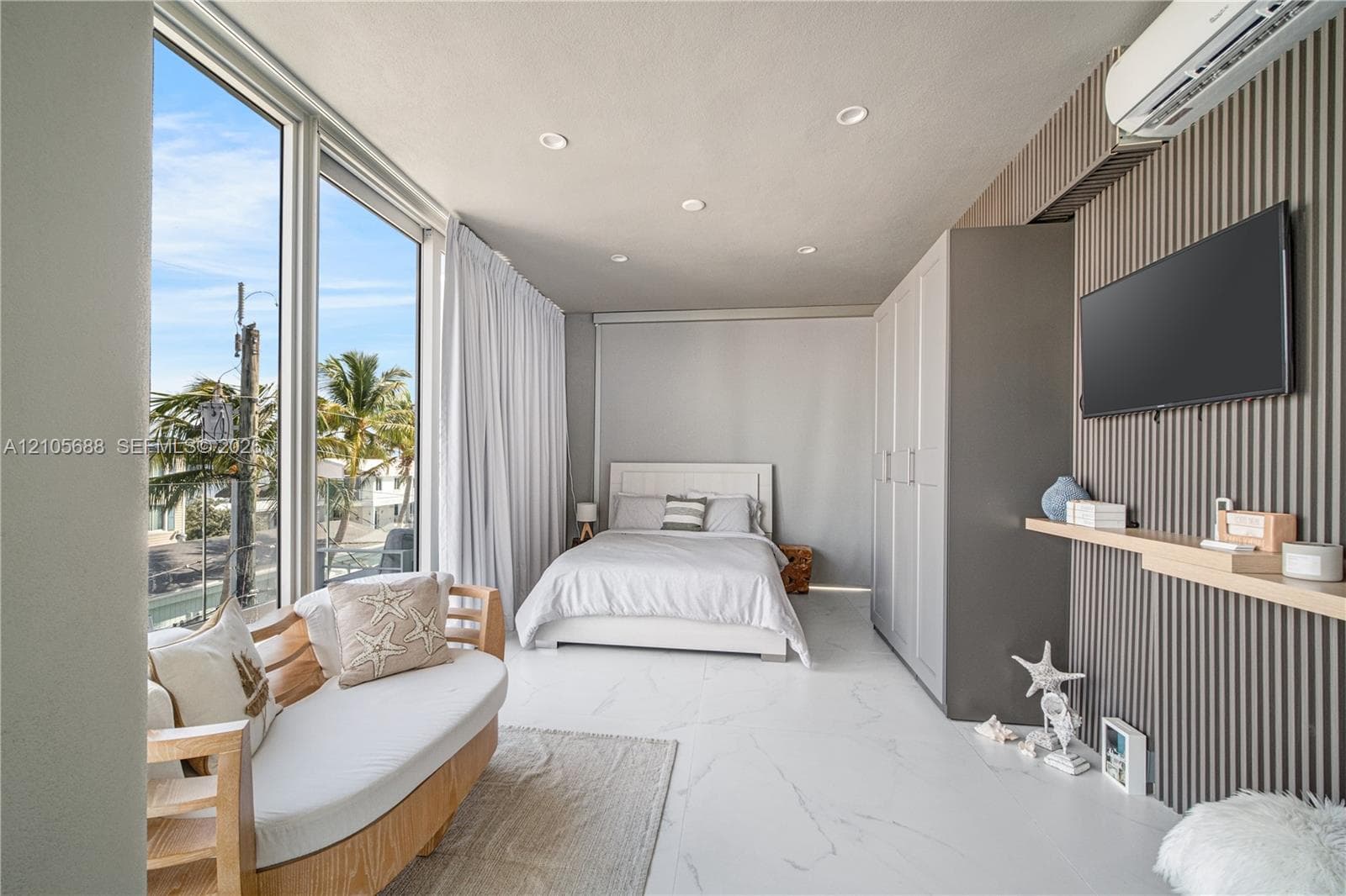 Floor-to-ceiling windows, polished stone-finish flooring, vertical slat accent wall, recessed lighting, and a built-in floor-to-ceiling wardrobe