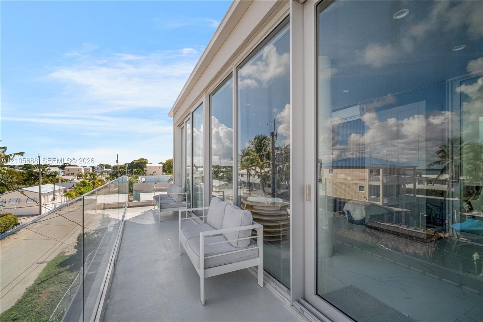 Expansive balcony featuring floor-to-ceiling glass wall panels, a seamless glass railing, recessed ceiling lighting, and smooth-finish flooring
