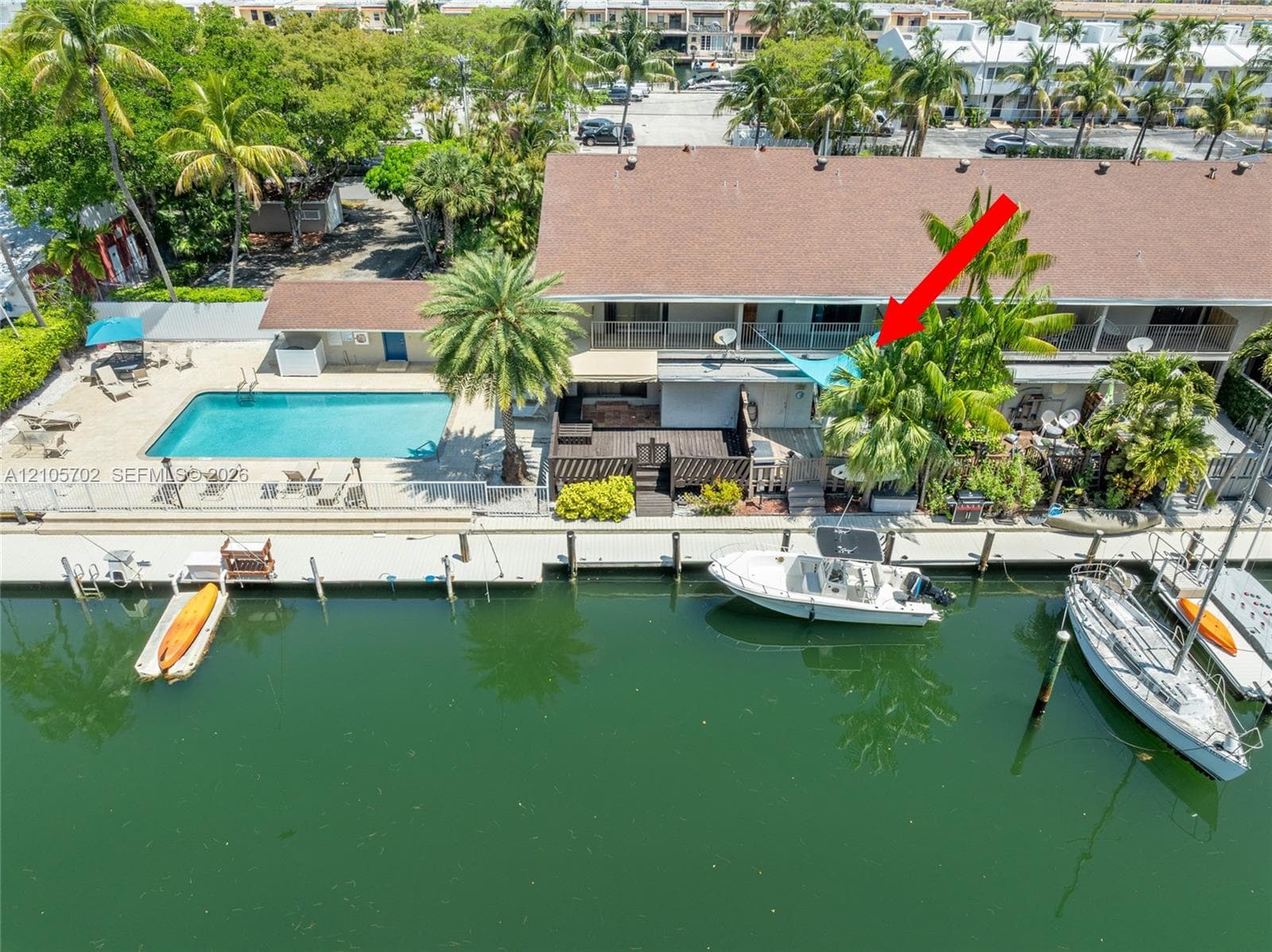Waterfront property featuring a private boat slip, dockage, swimming pool, and wood-finish deck