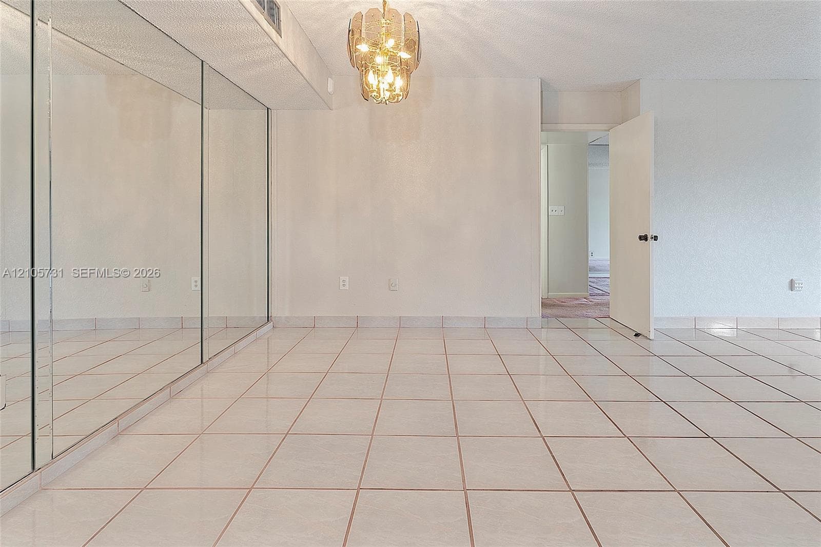 Ceramic tile flooring, full-wall mirrors, and a decorative tiered chandelier