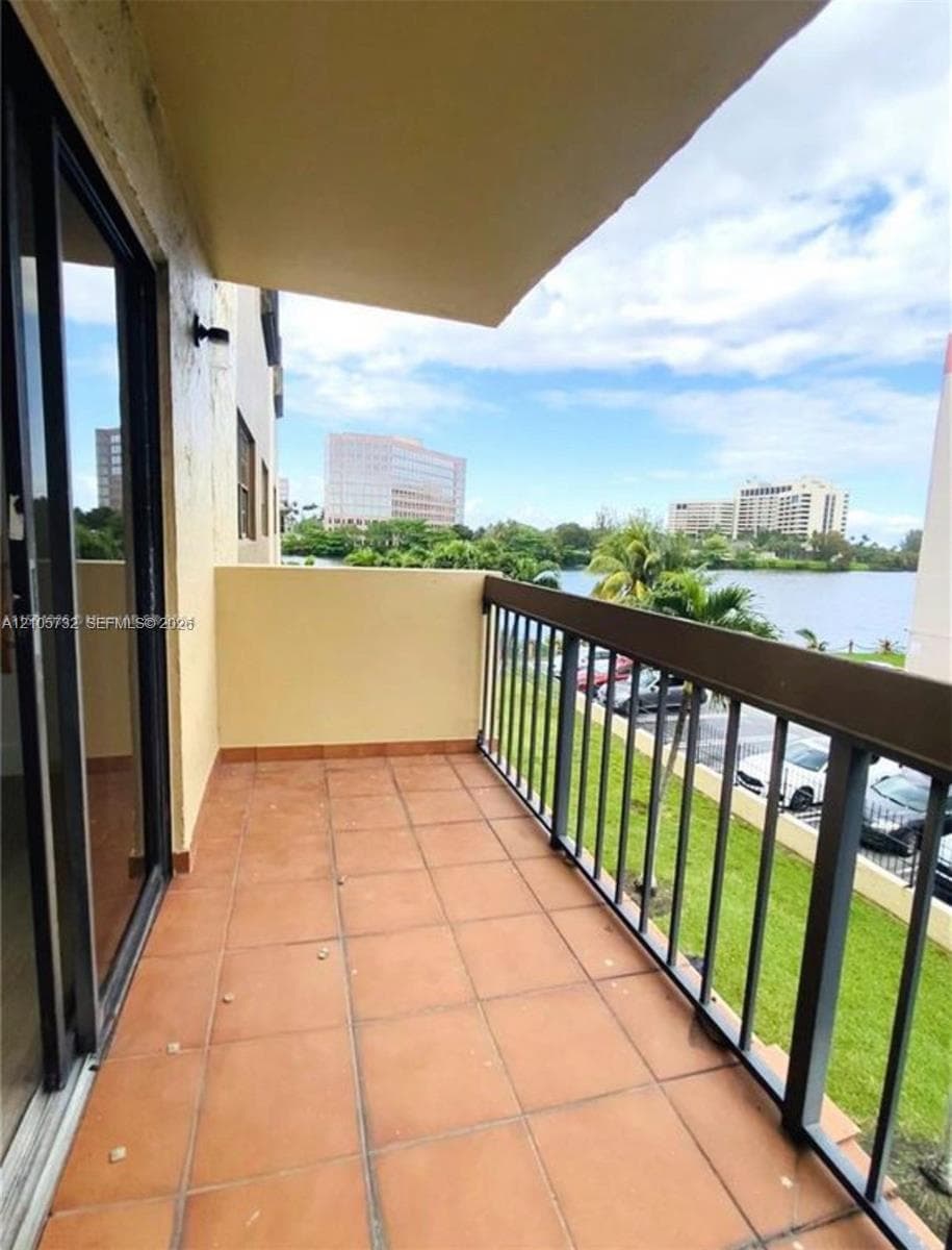 Private balcony featuring ceramic tile flooring, a metal railing, and an overhead canopy