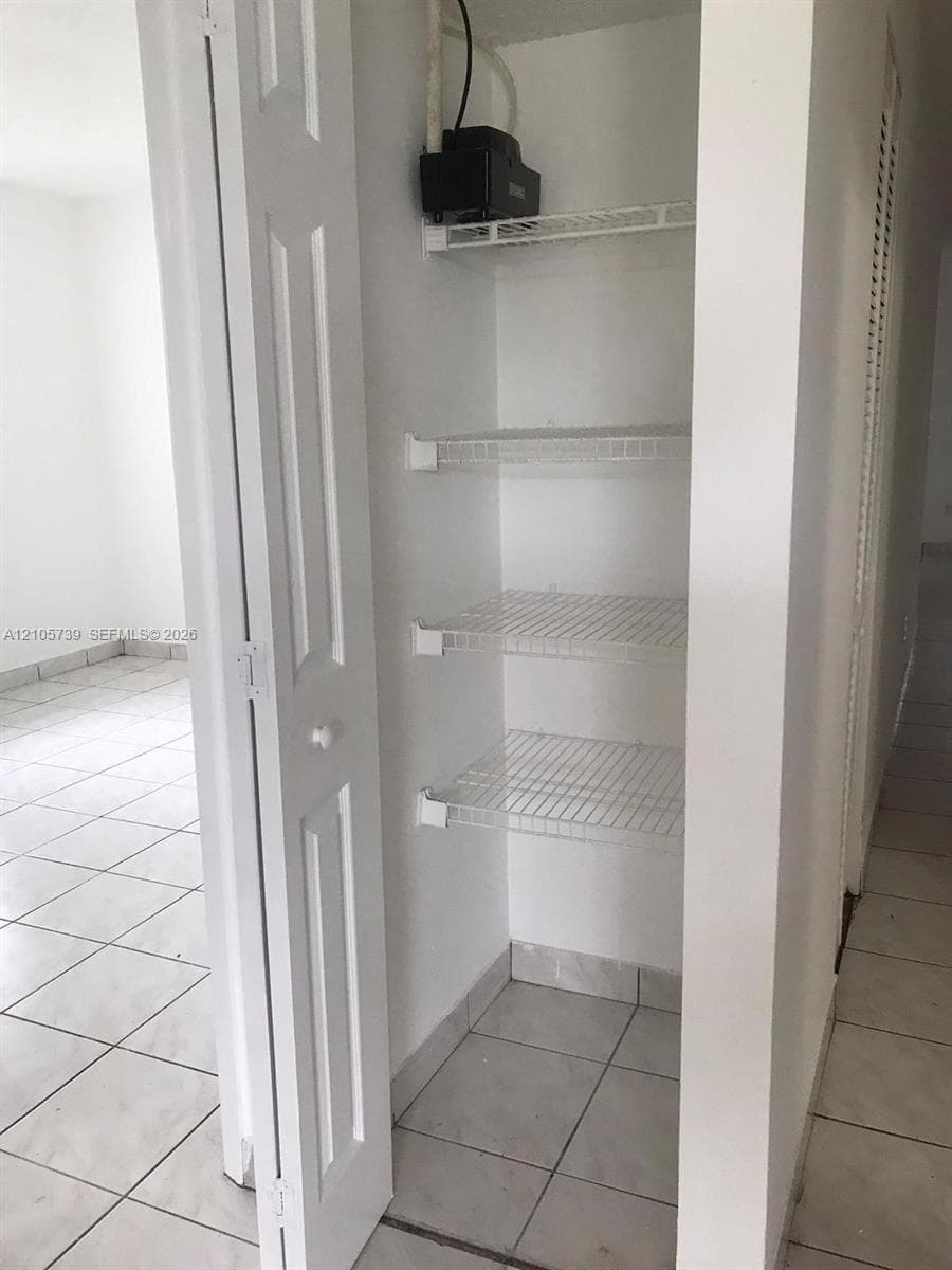 Built-in storage closet featuring white bi-fold doors and ventilated wire shelving
