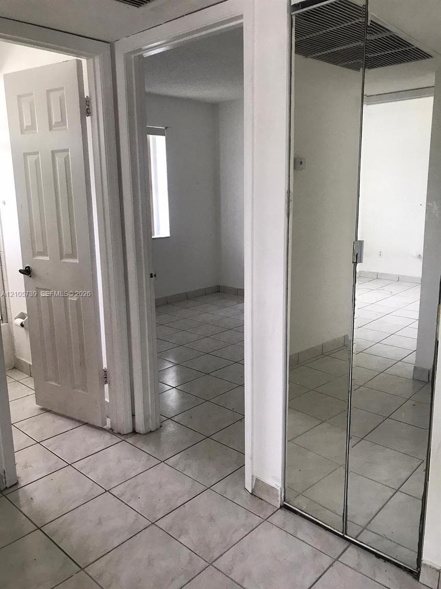 Ceramic tile flooring, full-height mirrored closet doors, and solid-core interior doors