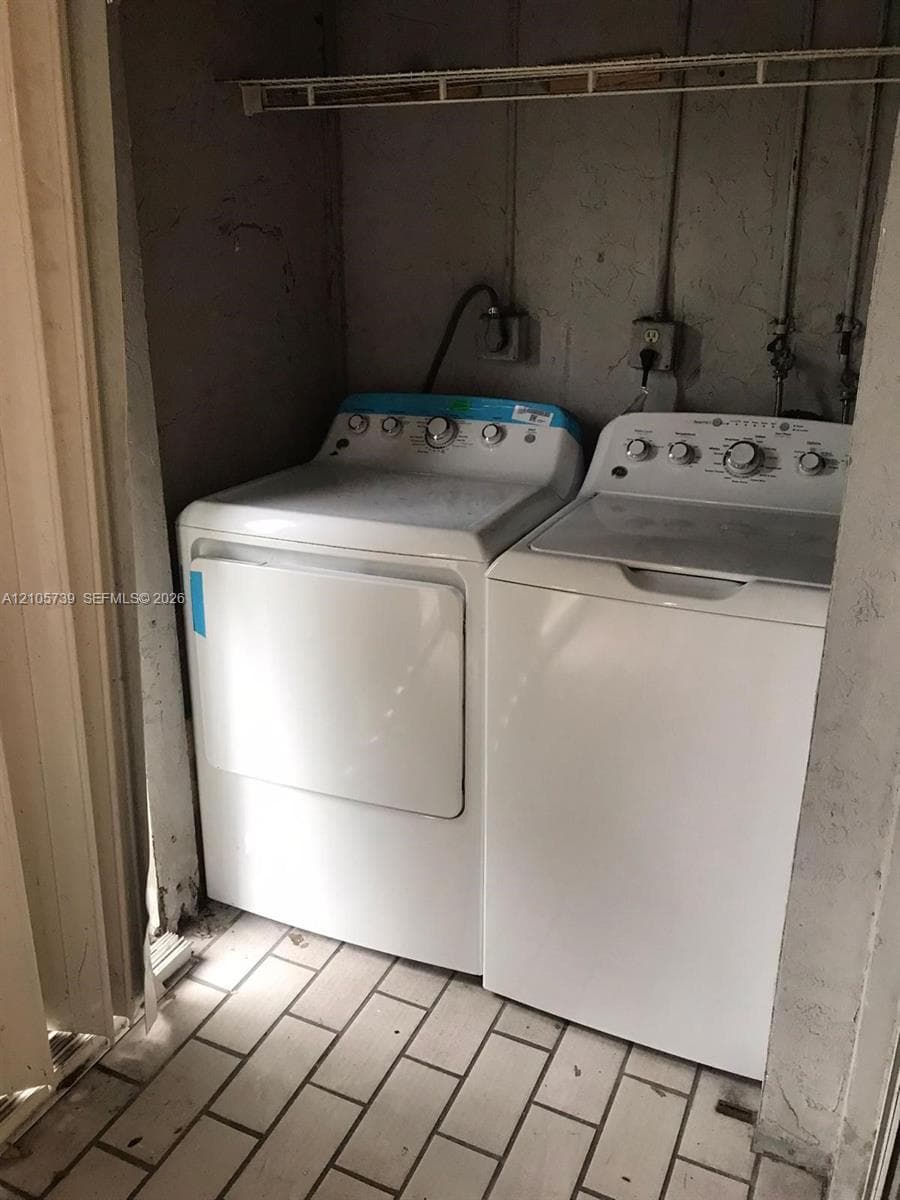 Laundry area featuring tile flooring, built-in wire shelving, and dedicated utility hookups