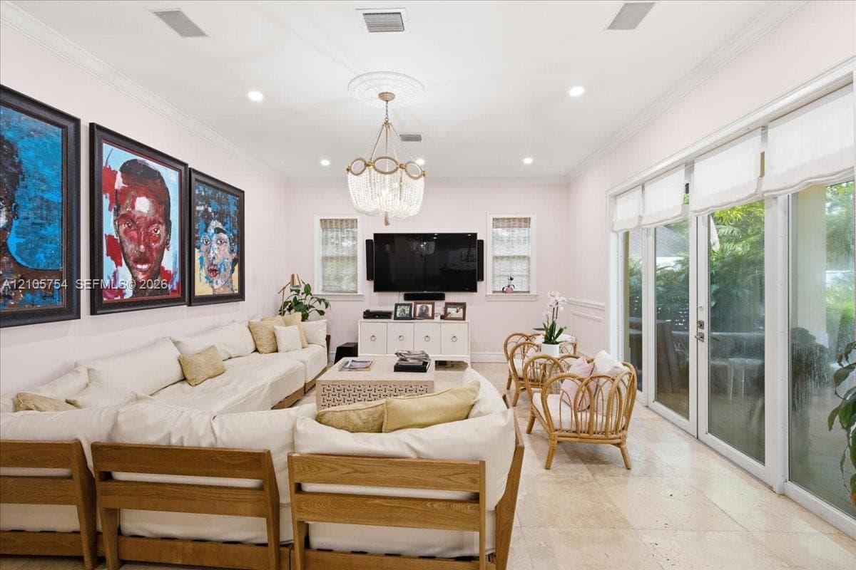 Living area featuring stone tile flooring, recessed lighting, crown molding, a decorative ceiling medallion with a tiered crystal chandelier, and floor-to-ceiling glass sliding doors