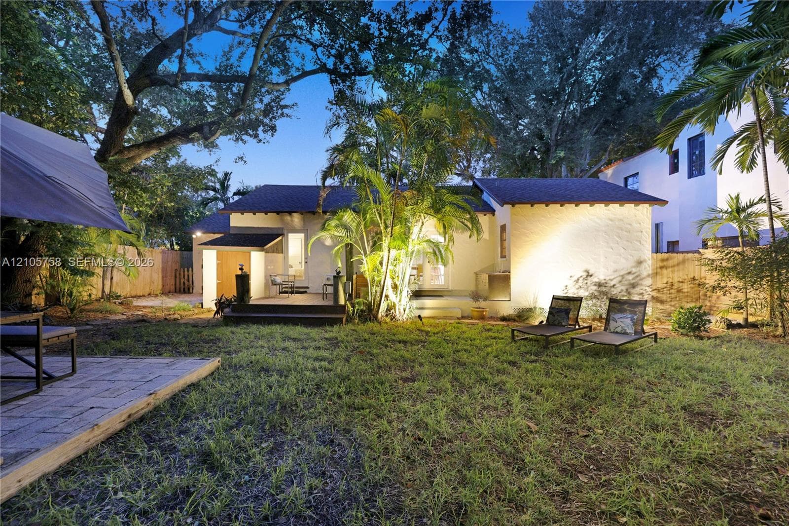 Backyard featuring mature trees, a multi-level wood deck, paver hardscaping, and privacy fencing