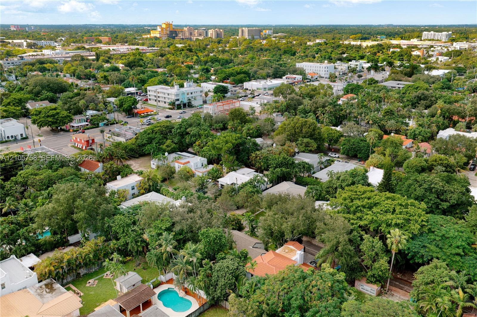 Aerial perspective featuring established tree canopy, residential hardscaping, and a swimming pool