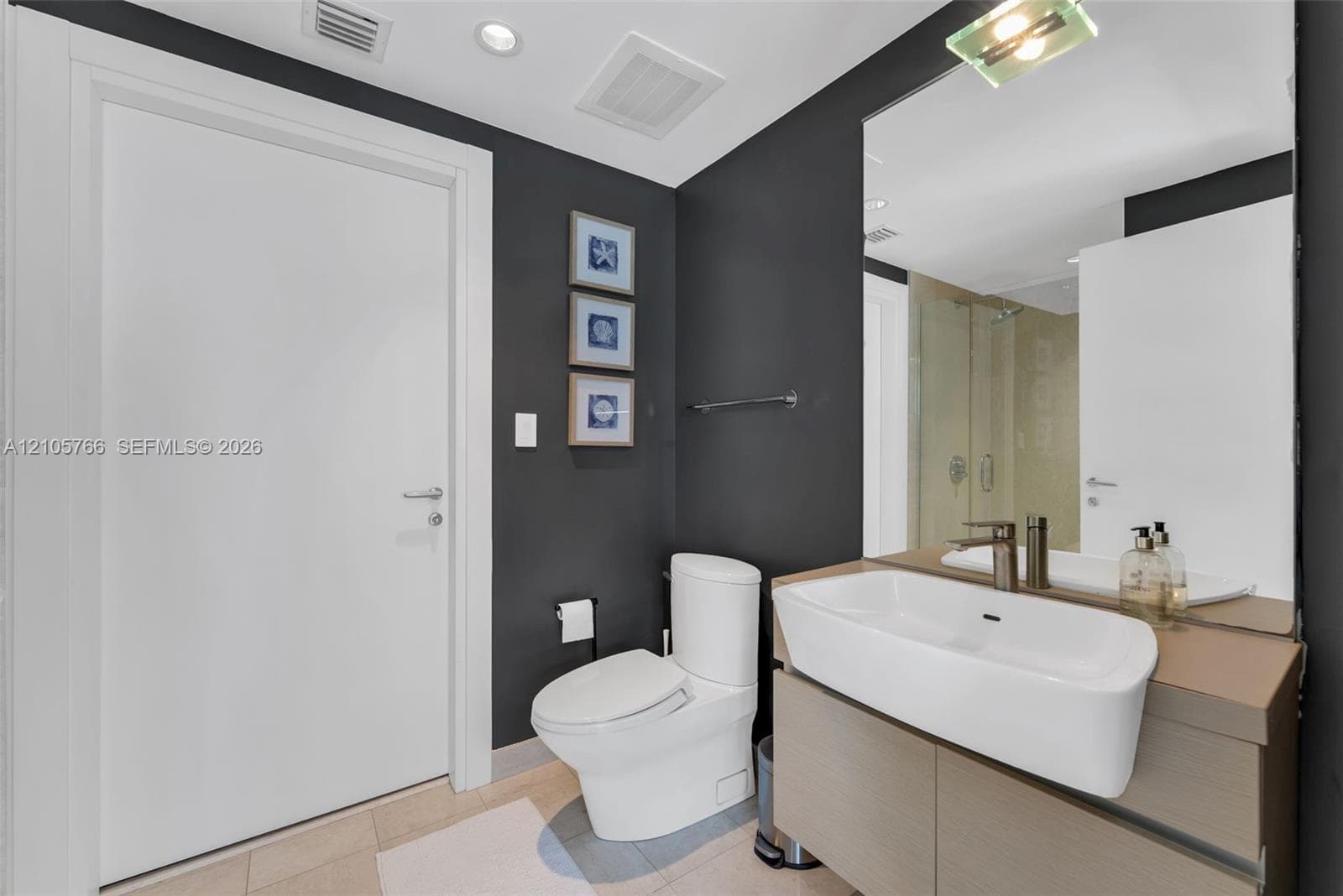 Second bath with floating vanity and a glass-enclosed rain shower.