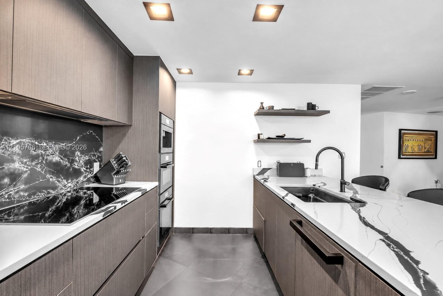 Kitchen with flush Miele cooktop, oven column and panel-front dishwasher.