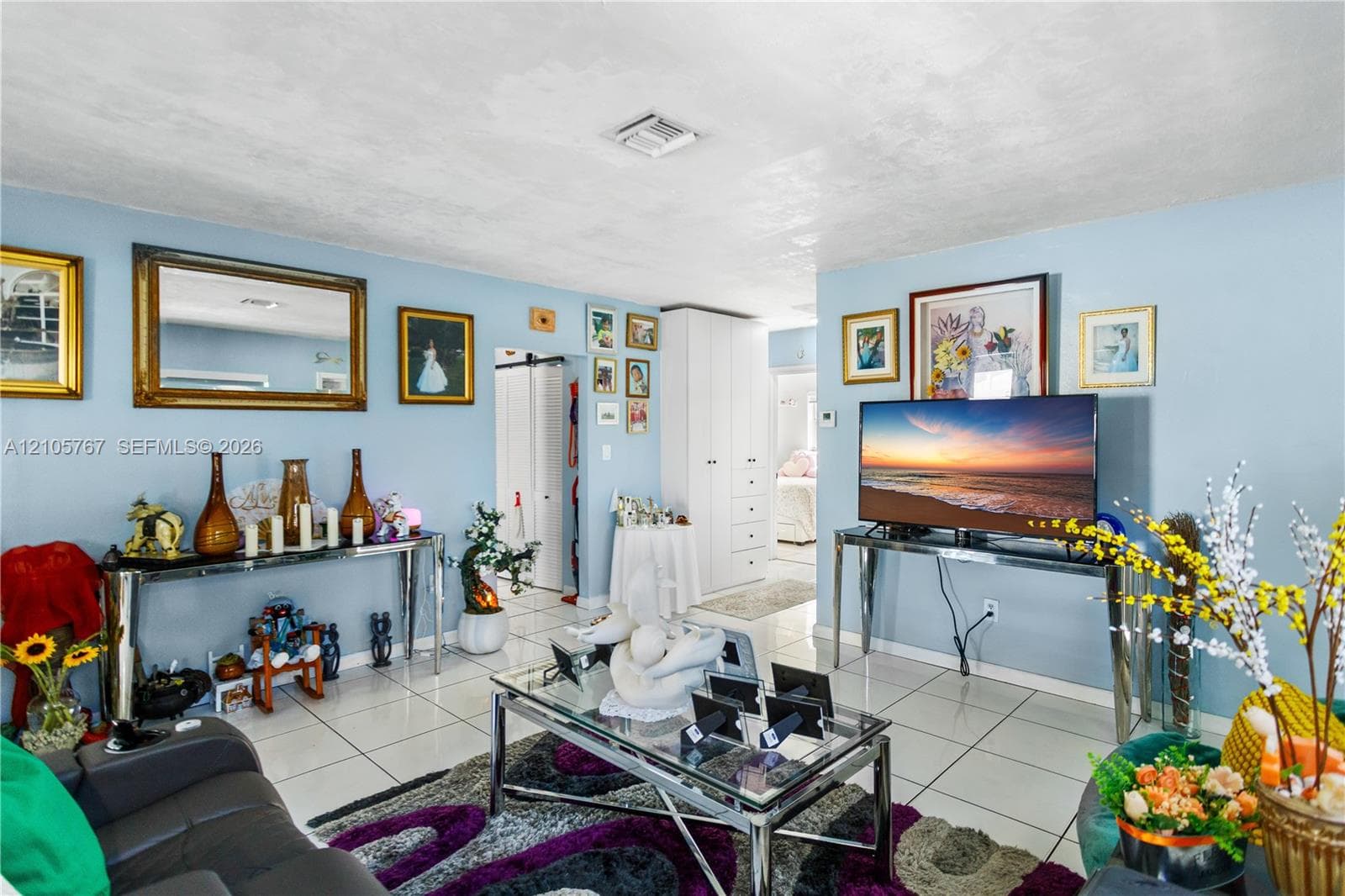 Living area featuring tile flooring and floor-to-ceiling built-in cabinetry
