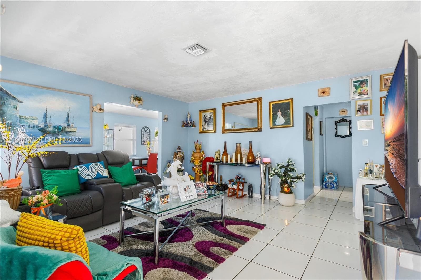 Living area featuring white ceramic tile flooring and light-toned wall finishes