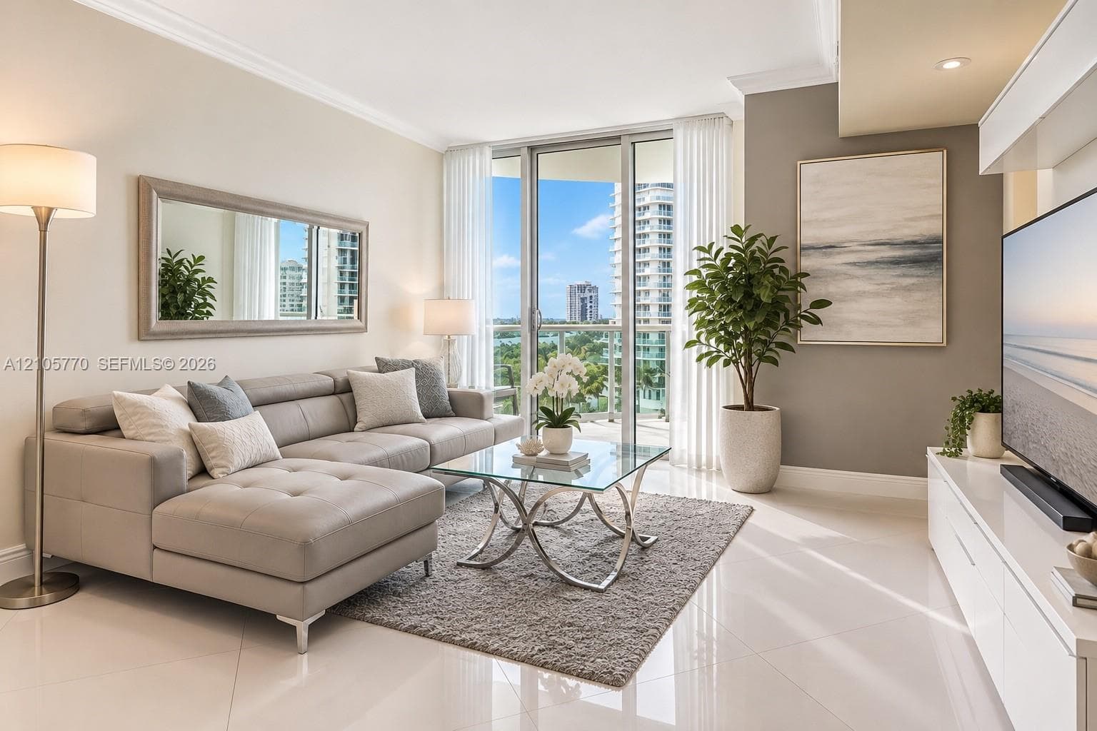 Living area featuring large-format tile flooring, floor-to-ceiling windows, and access to a balcony with exterior railing