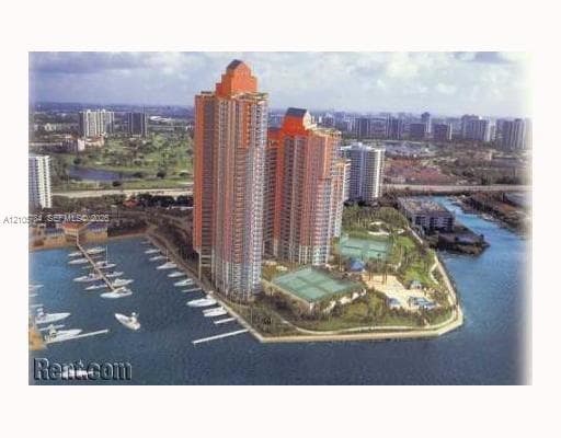 High-rise residential towers featuring an attached marina, tennis courts, paved walkways, and landscaped grounds