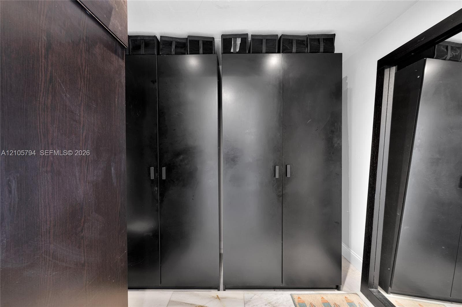 Built-in floor-to-ceiling cabinetry with a matte black finish and minimalist hardware