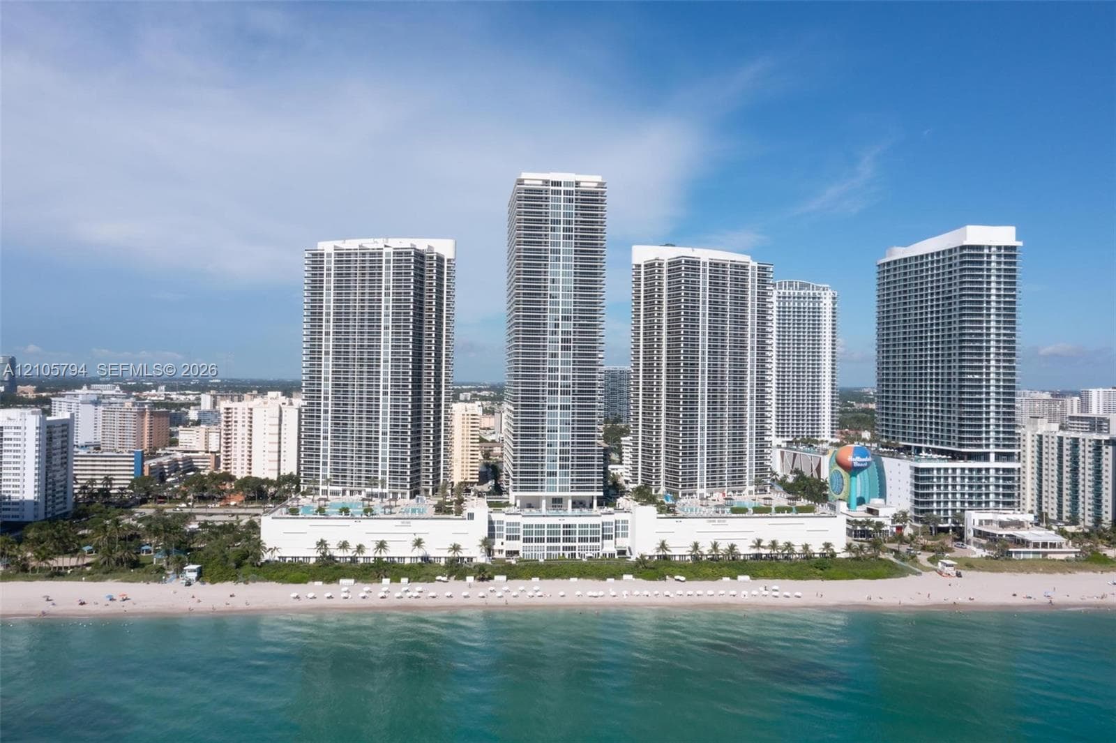 High-rise towers featuring direct oceanfront access, private pool decks, expansive glass facades, and ground-level parking structures
