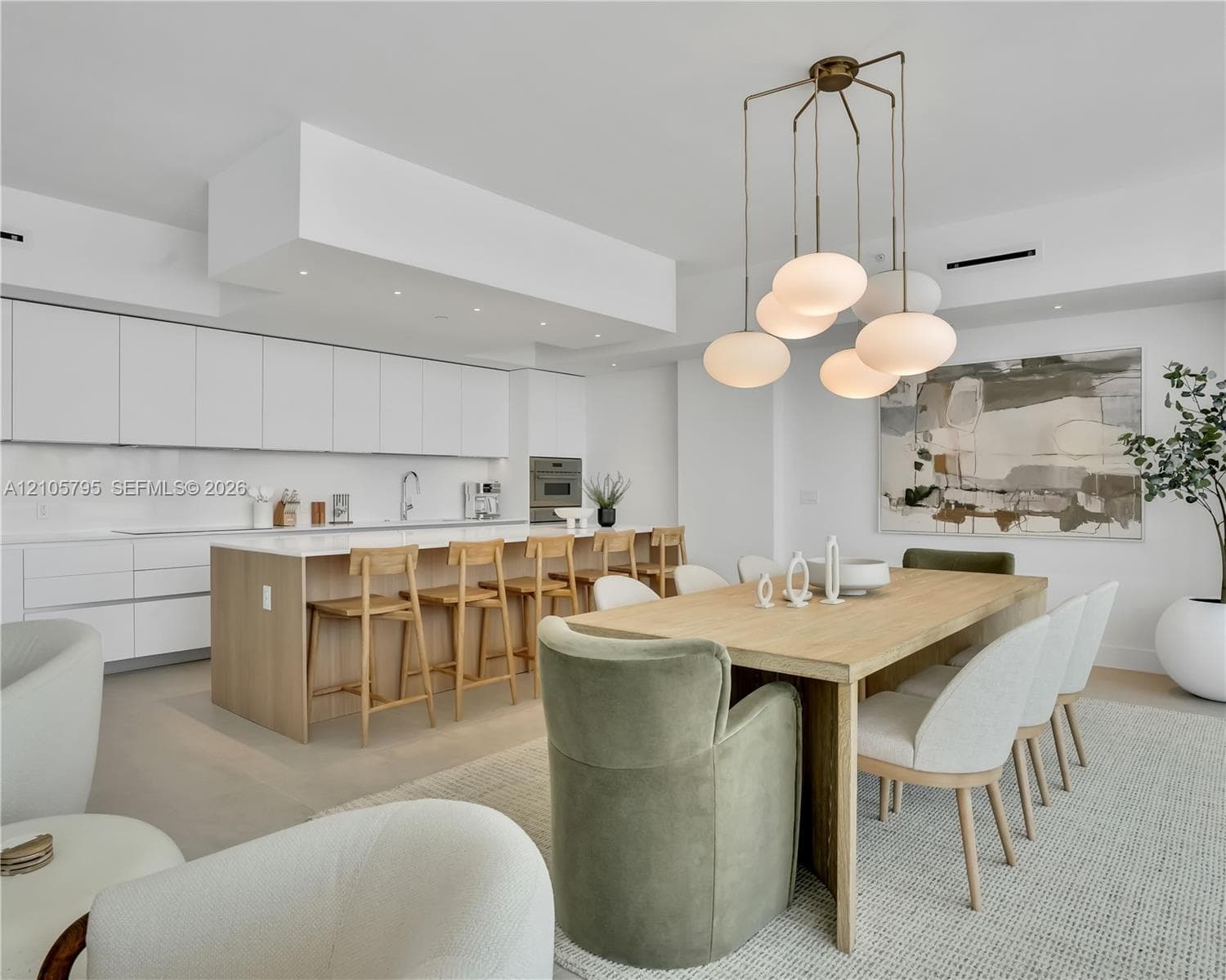 Kitchen featuring flat-panel cabinetry, a spacious island with quartz countertops, integrated built-in appliances, recessed lighting, and a modern multi-pendant light fixture
