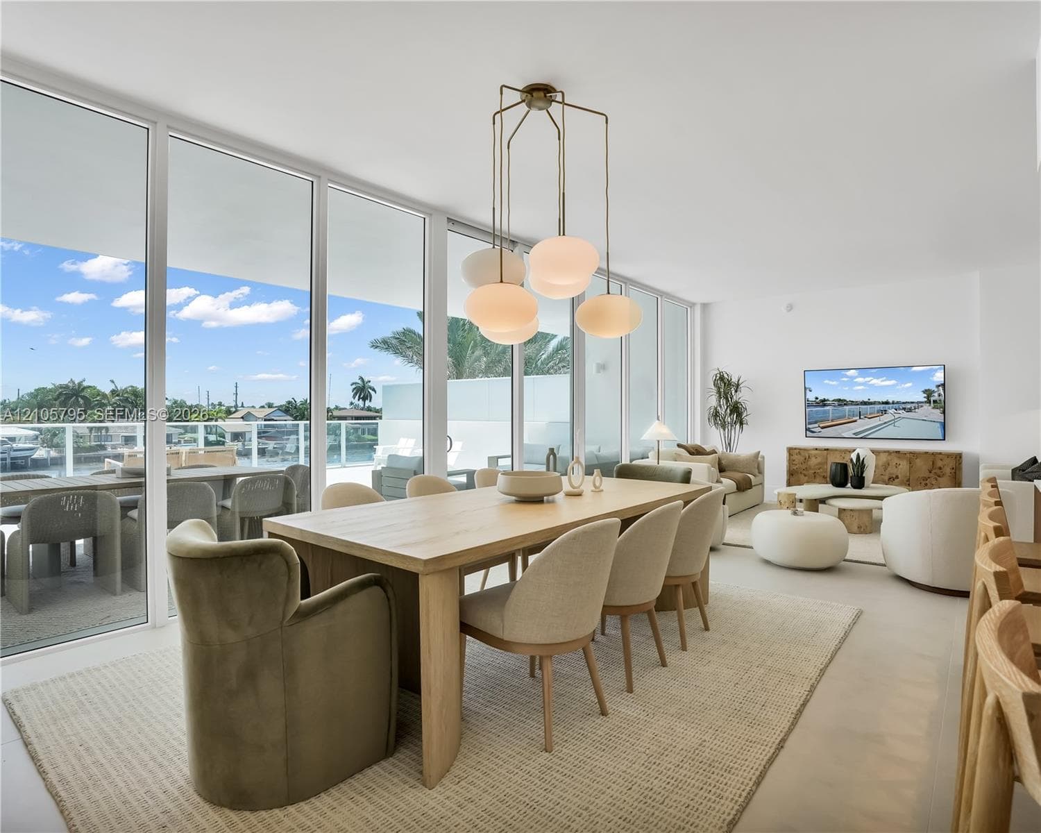 Floor-to-ceiling glass paneling, overhead multi-light pendant fixture, and large-format tile flooring