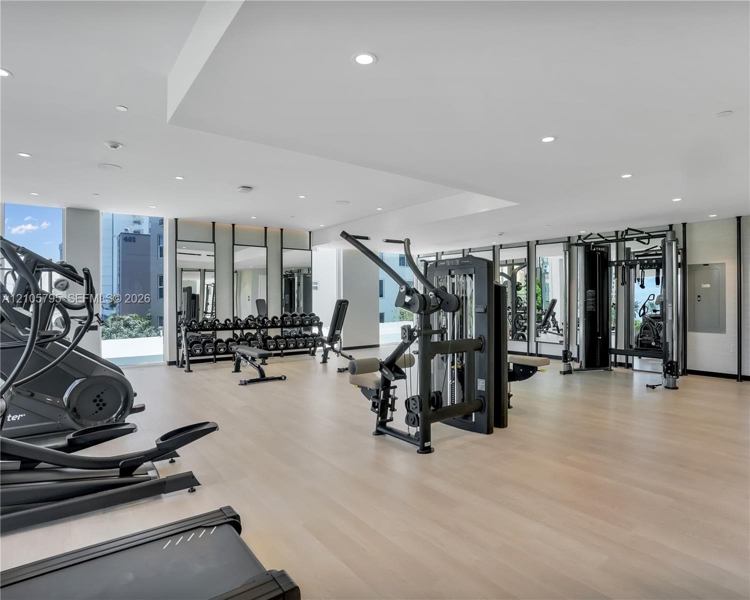 Fitness center featuring wood-finish flooring, recessed lighting, and full-length wall mirrors
