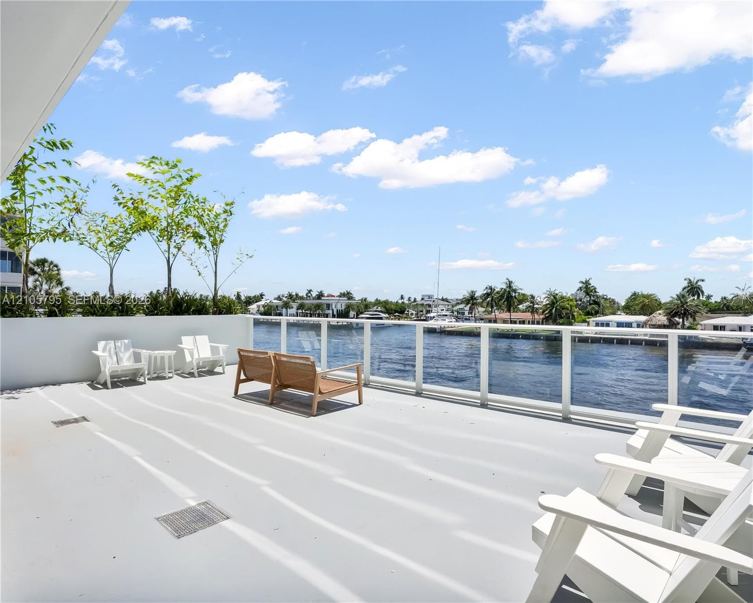Expansive open-air balcony featuring a solid surface floor and a protective glass panel railing