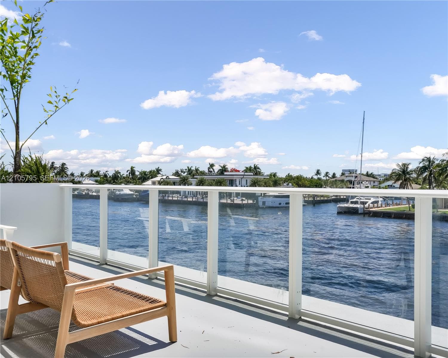 Elevated terrace featuring a water-facing glass panel railing and direct waterfront positioning