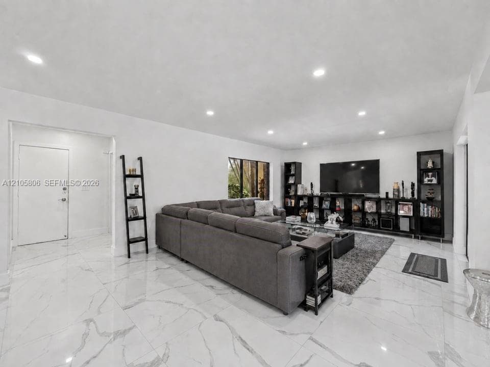 Polished large-format tile flooring with vein detailing, recessed ceiling lighting, and crisp neutral wall finishes