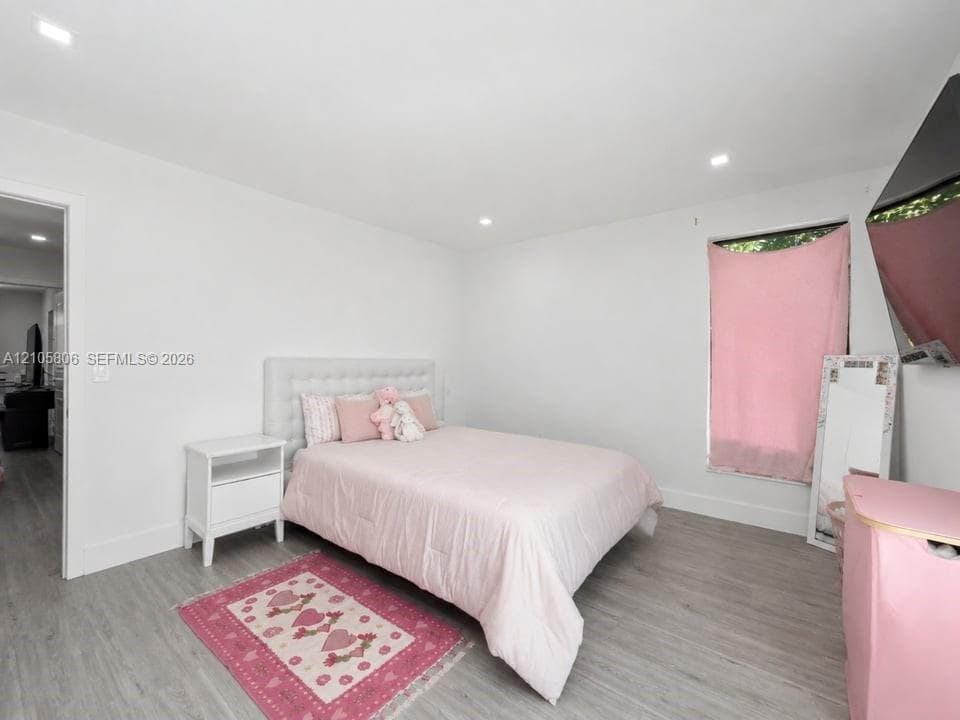 Neutral walls, wood-finish flooring, and recessed lighting