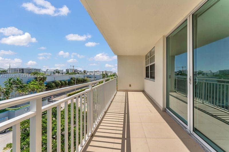 Private balcony featuring a white metal railing, large format tile flooring, and floor-to-ceiling sliding glass doors