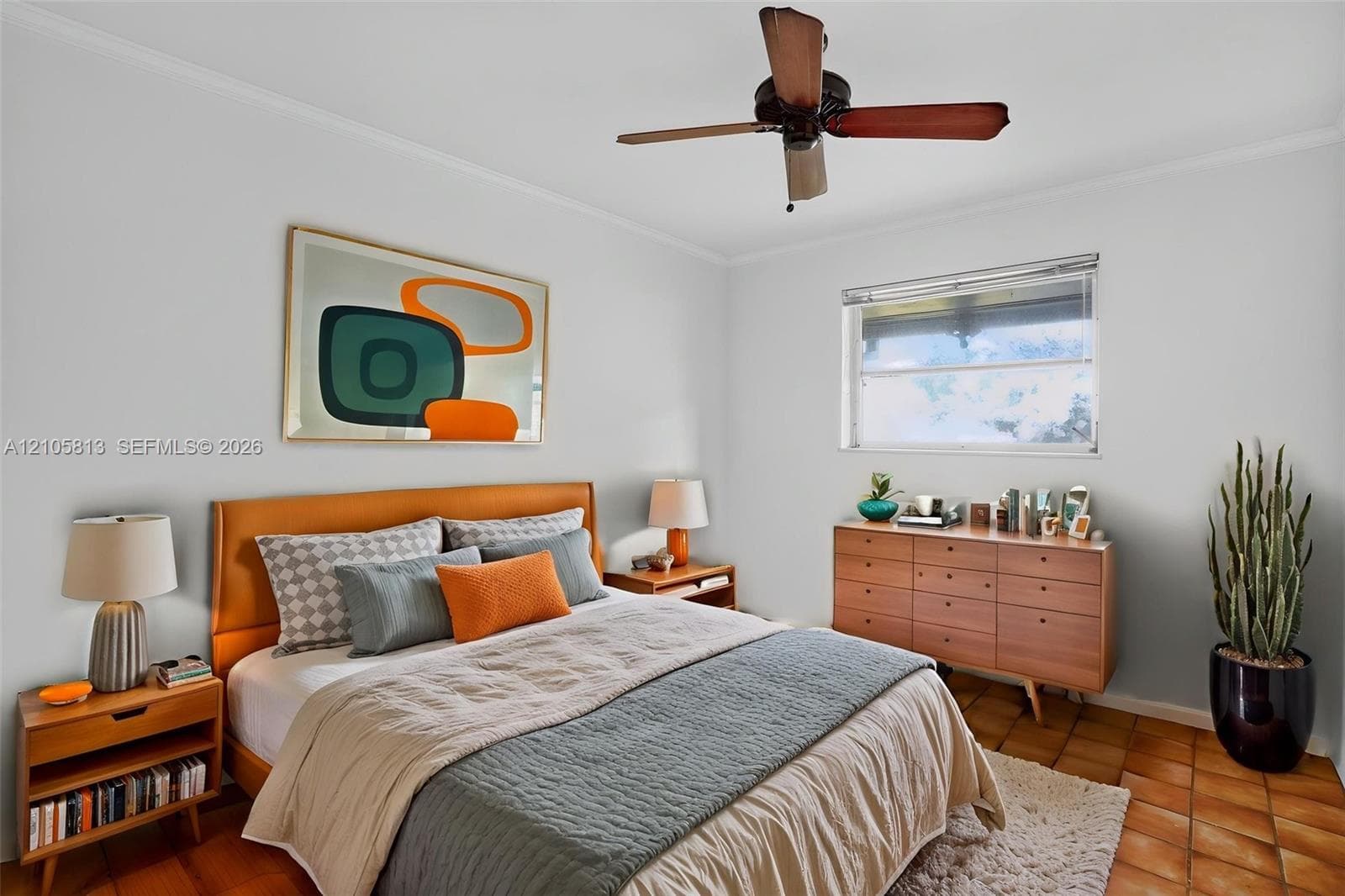 Bedroom featuring terra-cotta tile flooring, a horizontal single-hung window, and a ceiling fan with integrated lighting