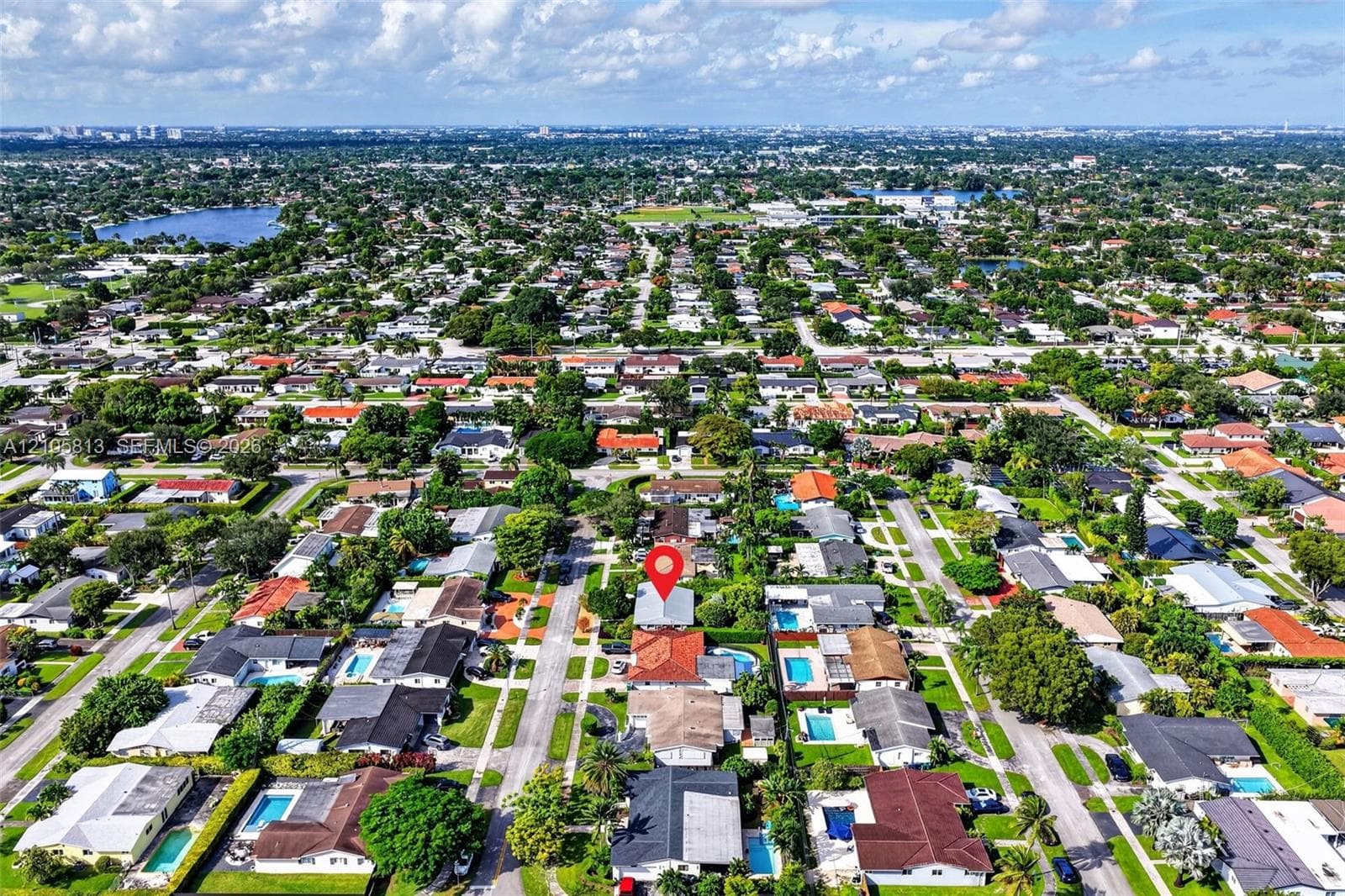 Aerial perspective of residential neighborhood featuring paved streets, mature trees, and detached single-story structures