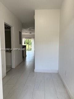 Interior hall featuring large-format light-toned tile flooring and neutral wall finishes