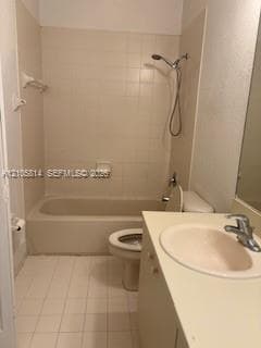 Bathroom featuring a built-in vanity with an integrated sink, porcelain tile flooring, and a tub-shower combination with ceramic tile surround
