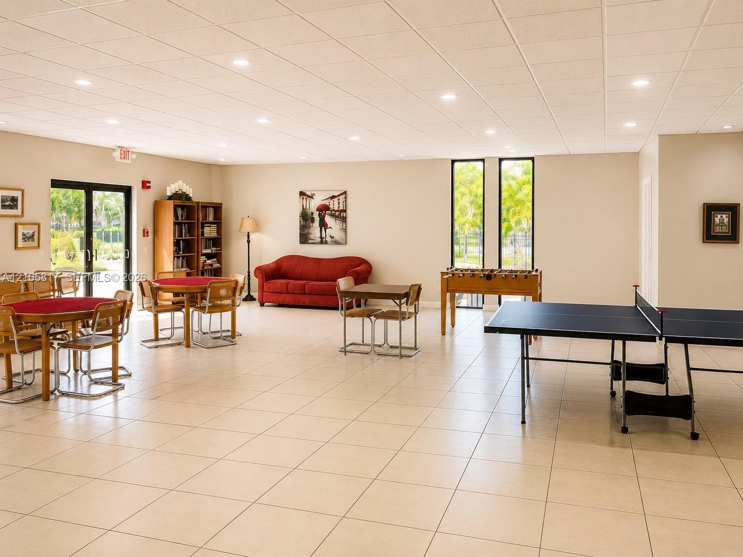 Spacious recreation area featuring large-format tile flooring, recessed lighting, and expansive floor-to-ceiling windows